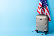 Welcoming the USA via Green Card! Side view image of stylish suitcase, American flag, and shimmering stars on blue, ready for your text or advertisement