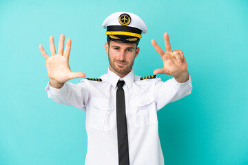 Wall Mural - Airplane caucasian pilot isolated on blue background counting eight with fingers