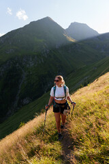 girl with a backpack hiking in the evening light