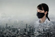 Portrait Asian children girl wear N95 mask to protect PM 2.5 dust and air pollution. Portrait of Thai student wearing protection mask over smog city building with bad weather, pm2.5 concept background