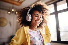 Happy Funny Gen Z Hipster African American Teen Girl Wearing Headphones Dancing At Home, Listening Music On Mobile Phone, Having Fun Feeling Funky Moving In Living Room, Authentic Shot