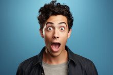 Young Man Expressing Surprise And Shock Emotion With His Mouth Open And Wide Open Eyes. Isolated On Blue Background