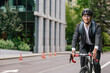 © zinkevych - Young man in black suit riding a bike