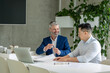 © zinkevych - Men architects working on construction plans, engineers discussing on project in office.