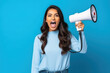 Young woman screaming in megaphone.