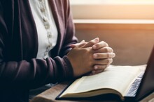 Women's Hands Are Folded In Prayer On A Holy Bible Over A Laptop In Church Concept For Faith, Religion, Love, And Forgiveness. Holy Bible Study Reading Together In Sunday School.Online, Generative AI
