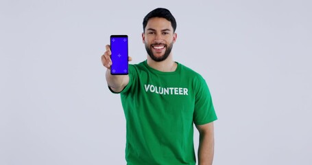 Poster - Face of volunteer, green screen and phone of man in studio isolated on white background mockup space with tracking markers. Portrait, happy and charity worker on smartphone for community service app