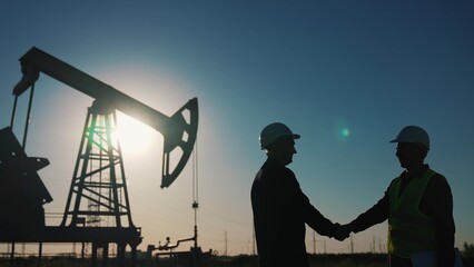 handshake business oil contract. handshake a worker and businessman shaking hands against backdrop o