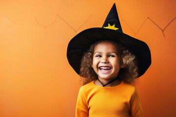 Happy laughing child girl in witch costume to Halloween on color background