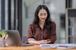 © David - Young attractive business asian woman checking searching document  her project with laptop computer in the office room.