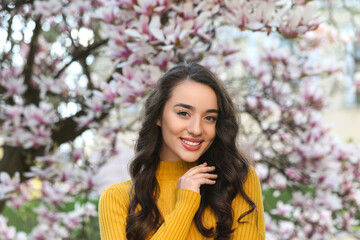 Sticker - Beautiful woman near blossoming magnolia tree on spring day