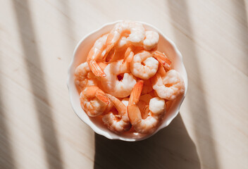 Wall Mural - Peeled shrimps in a bowl isolated on white background. Top view