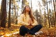 © maxbelchenko - Young woman performs yoga exercises in the autumn forest, on fallen leaves. Lifestyle, meditation concept. Enjoying.