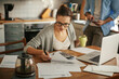 © Geber86 - Worried young caucasian woman going over her bills and home finances in the morning in the kitchen