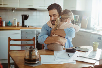 Wall Mural - Young single father finding hope in his daughters embrace while stressing over bills and home finances in the morning in the kitchen