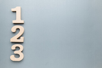 Poster - One, Two, Three, wooden numbers on gray paper with copy space