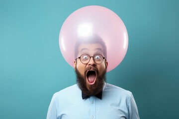 Wall Mural - A man with a beard and glasses wearing a pink balloon on his head. This image can be used to depict a fun and quirky individual or to symbolize creativity and self-expression.