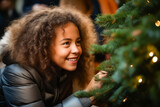 Fototapeta  - Young girl smiling next to christmas tree with smile.