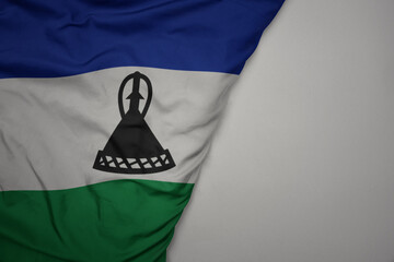 big waving national colorful flag of lesotho on the gray background.