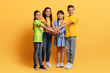 © Prostock-studio - Happy multiethnic teenagers holding hands on top of each other