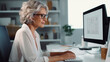 Senior adult woman working on desktop computer in glasses