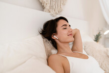 Woman Wake Up In Morning In Boho Style Bedroom, Sitting On Bed, Listening To Music, Relaxing