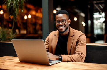 Portrait of a smiling black businessman with laptop at cafe. AI Generated