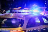 Fototapeta  - Policja polska radiowóz w akcji na ulicy w ruchu. Policja w deszczu. 