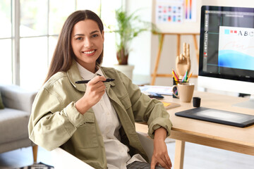 Canvas Print - Female interior designer working at table in office