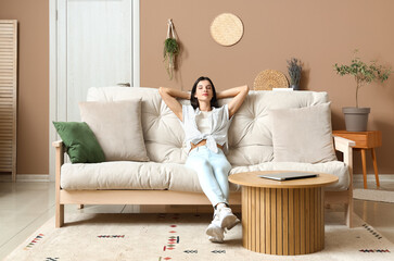 Canvas Print - Young woman resting on couch in living room