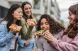 © PintoArt - beautiful young fun women enjoying delicious pizza - tourist women in European city with takeaway food -