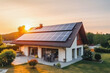 Solar panels on large family house with sunset light in the background