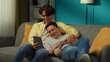 © kinomaster - Shot of a homosexual couple at home. They are laying on the couch, watching photos or videos on a tablet, hugging, laughing and expressing love to each other.