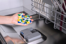 Dishwashing capsules. Dishwasher Detergents in hands.dishwasher gel capsules. Brilliant cleanliness.