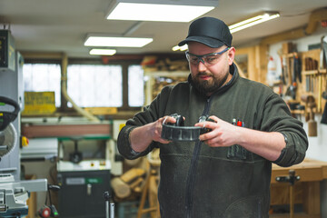 Man carpenter putting on his protective headphones for work, carpentry background. High quality photo