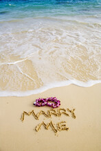 Turquoise Ocean, Foaming Shore Water, Orchid Lei, Marry Me Written In Sand