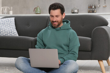 Poster - Man using laptop on floor at home