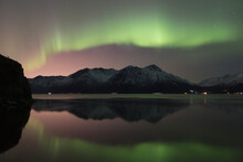 Aurora Borealis Above The Chugach Mountains And Reflecting In The Waters Of Turnagain Arm; Alaska United States Of America