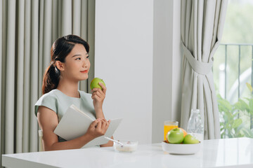 Wall Mural - beautiful young woman reading book during coffee break at home