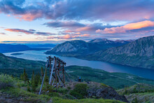 Two Women On Mountain Top Next To A Mining Relic Enjoying View Along Sam McGee Trail, Yukon, Canada
