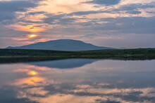 A Smoky Sunset Over Two Moose Lake Along The Dempster Highway; Yukon Territory, Canada