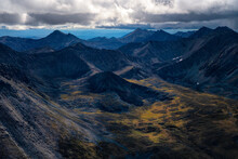Aerial View Of Rugged Mountain Peaks And A Valley With Tundra In Autumn Colours In Tombstone Territorial Park Along The Dempster Highway In The Yukon Territory; Yukon, Canada