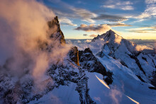 Morning Fog Rises From Peaks In The Alps Near The Matterhorn; Zermatt, Switzerland