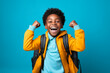 © zamuruev - happy winner African American school boy on blue background celebrates new success, power, energy.
