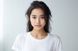 © NaphakStudio - Portrait of a smiling Asian woman wearing a t-shirt with standing and looking at the camera. Face of healthy woman, Lifestyle portrait photography.