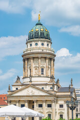 Wall Mural - Berlin, Germany - June 8, 2021: View over the Gendarmenmarkt in Berlin with French Cathedral in historical and business downtown at summer sunny day and blue sky.