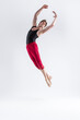 © danmorgan12 - Contemporary Ballet of Young Flexible Athletic Man Posing in Red Tights in Flying Dance Pose With Hands Connected in Studio on White.