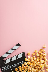 Wall Mural - Movie Magic Display: Vertical top view of popcorn and a clapperboard on a pastel pink surface, providing space for your text or promotional message