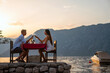 © NDABCREATIVITY - Couple in love drinking wine on romantic dinner at sunset on the beach. People love travel concept