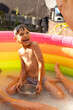 © Татьяна Волкова - Laughing, having fun, playing wet boy in inflatable pool on summer day in backyard. Games in water. Positive emotions.